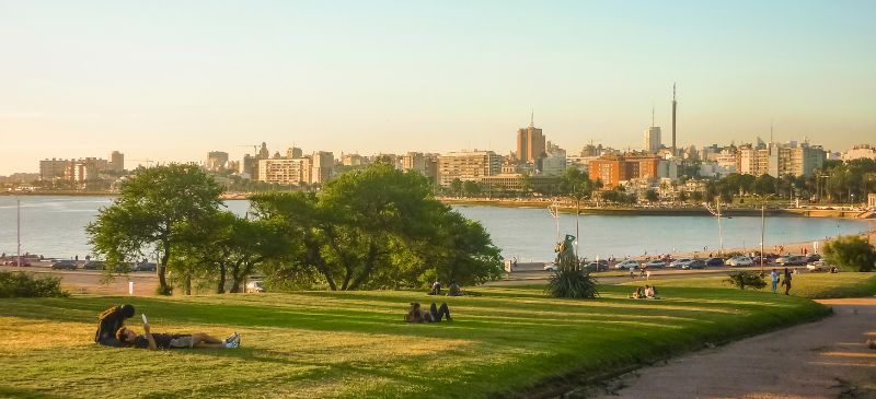 Locals lounging on the grass at sunset, Playa Ramirez in the background