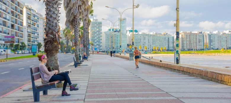 A woman relaxes on a bench along the Rambla at Playa Pocitos